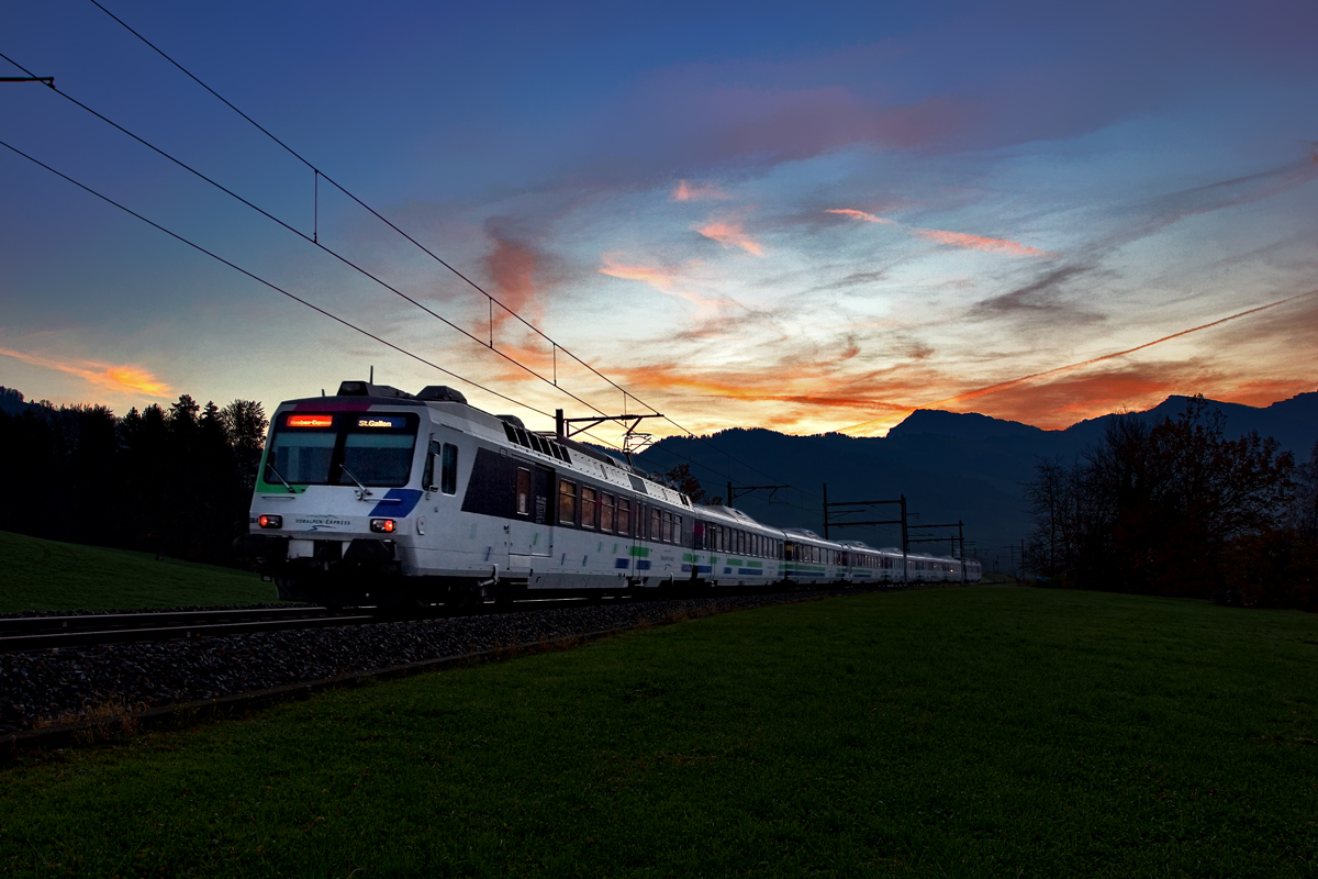 Nachschuss bei einem schönen Morgenrot in den Voralpen fährt der Voralpenexpress Triebzug RBDe 561 084 in Kaltbrunn vorüber.Bild vom 11.11.2015