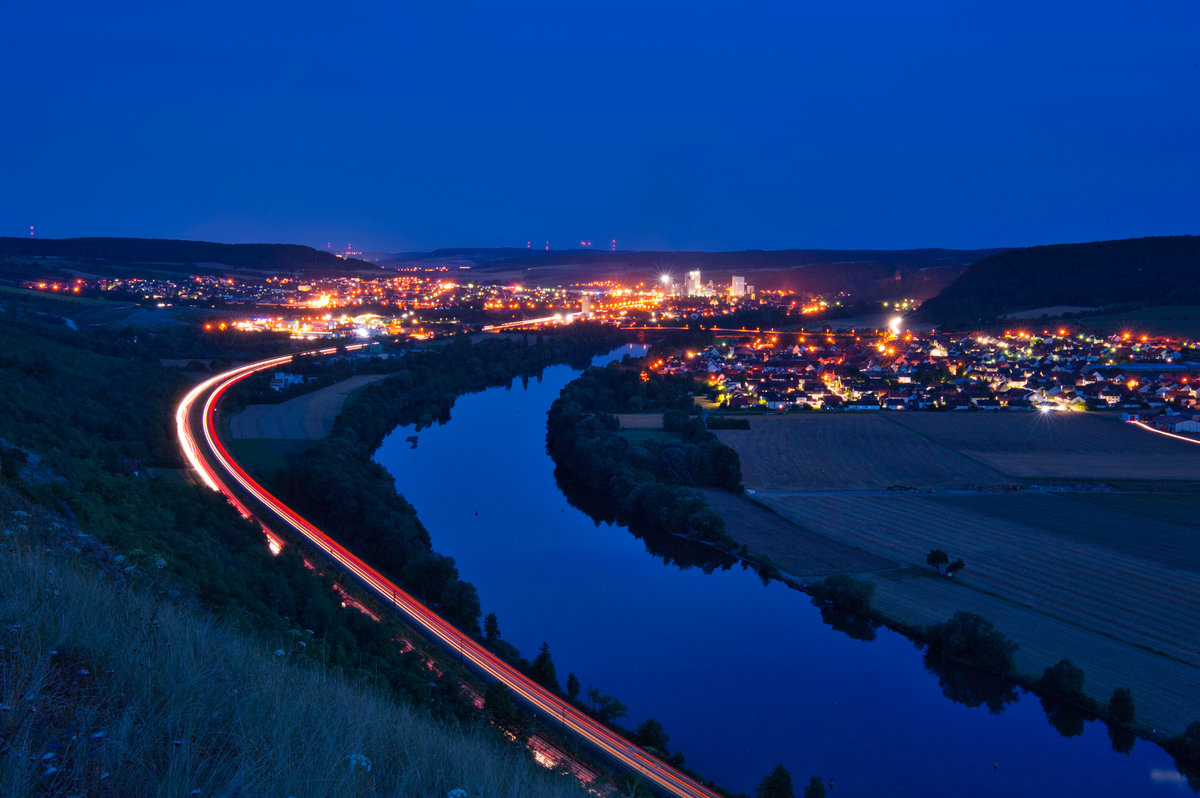 Nächtlicher Blick auf Karlstadt: Mit knapp fünf Minuten Belichtungszeit konnte dabei neben der viel befahrenen Straße auch zwei Regionalzüge aufgenommen werden, die das Tal durchfuhren, 01.08.2019