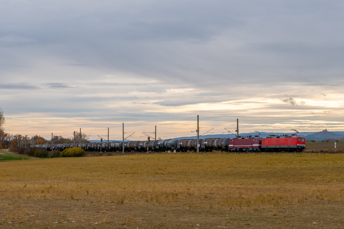 Nahe Cobstädt legen sich 143 848 und 143 936 in die Kurve, am Haken ein Kesselzug von Großkorbetha nach Ingolstadt. Im Hintergrund thront die Wachsenburg.