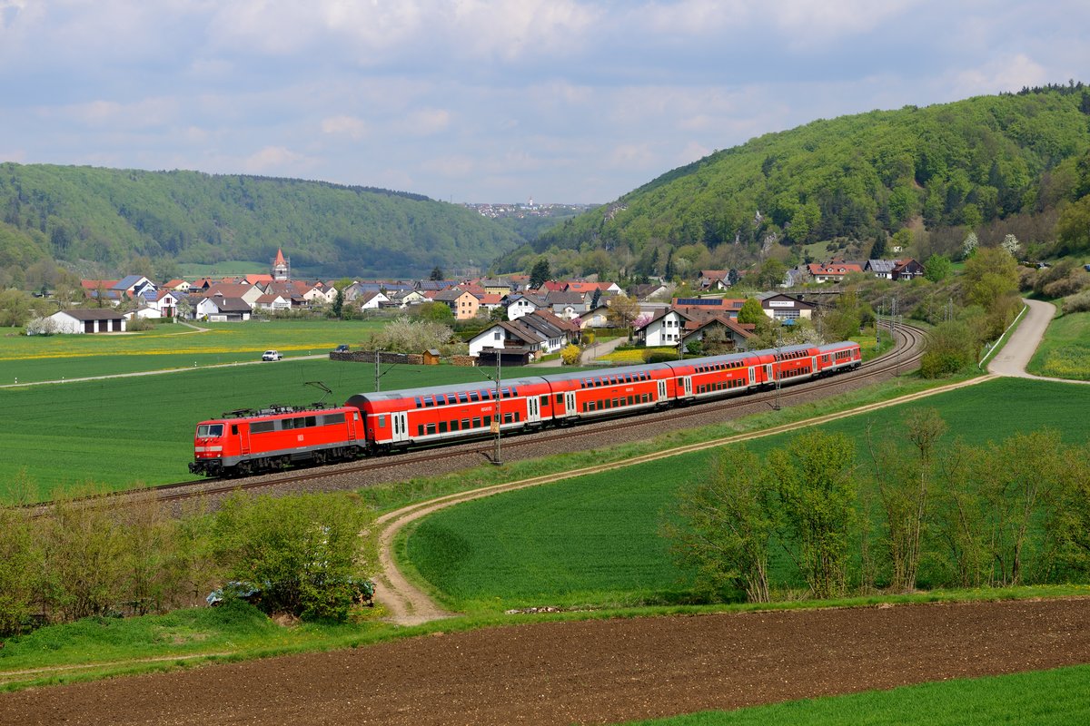 Nahverkehr im Altmühltal: Stündlich verkehrt ein Doppelstockzug, geführt von einer Lok der Baureihe 111, von München nach Nürnberg und umgekehrt. Am 29. April 2015 wurde stellvertretend 111 182 mit ihrer RB 59152 nach Nürnberg HBF bei Breiterfurt aufgenommen.