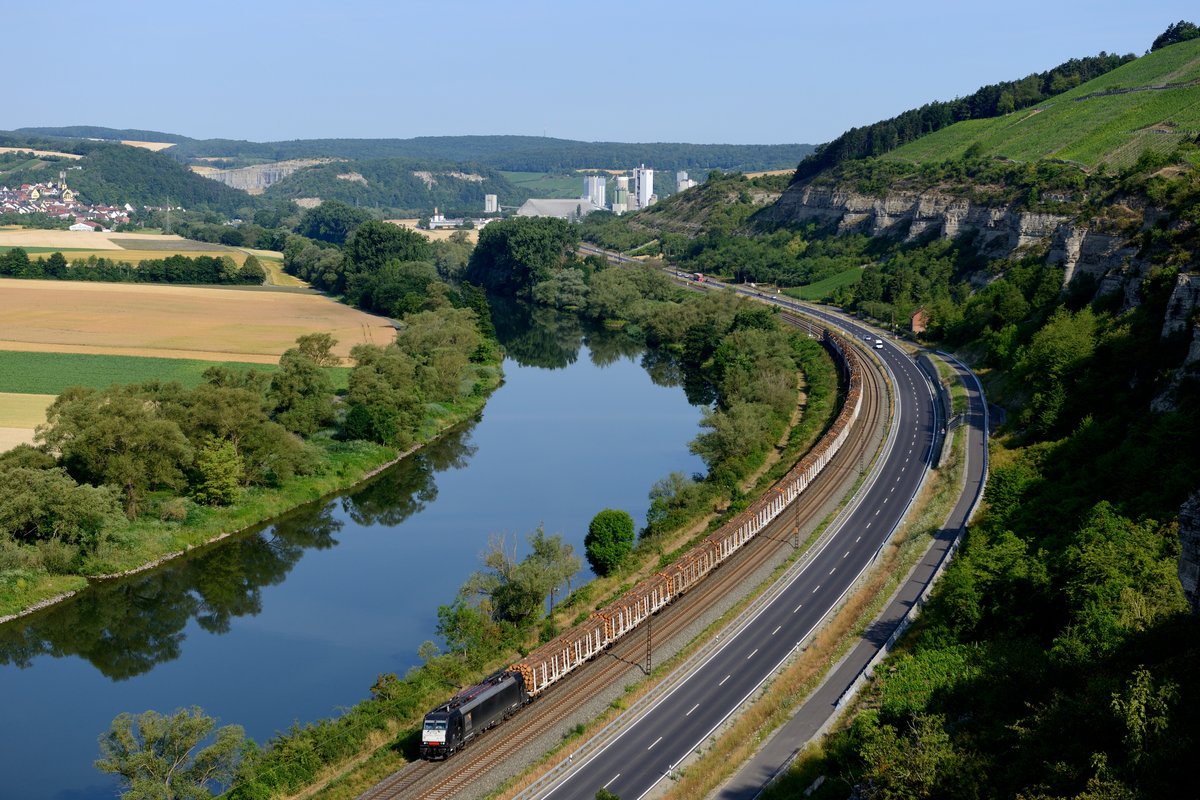 Natürlich durfte am 03. Juli 2014 auch nicht der Blick von den Weinbergen zwischen Karlstadt und Himmelstadt fehlen: 185 571 fährt aktuell für die OHE und hat hier einen Holzzug am Haken, den sie von Padborg in Dänemark nach Gratwein-Gratkorn in Österreich beförderte. Auftraggeber ist der Südafrikanische Sappi-Konzern, der weltweit in der Papierproduktion aktiv ist.
 