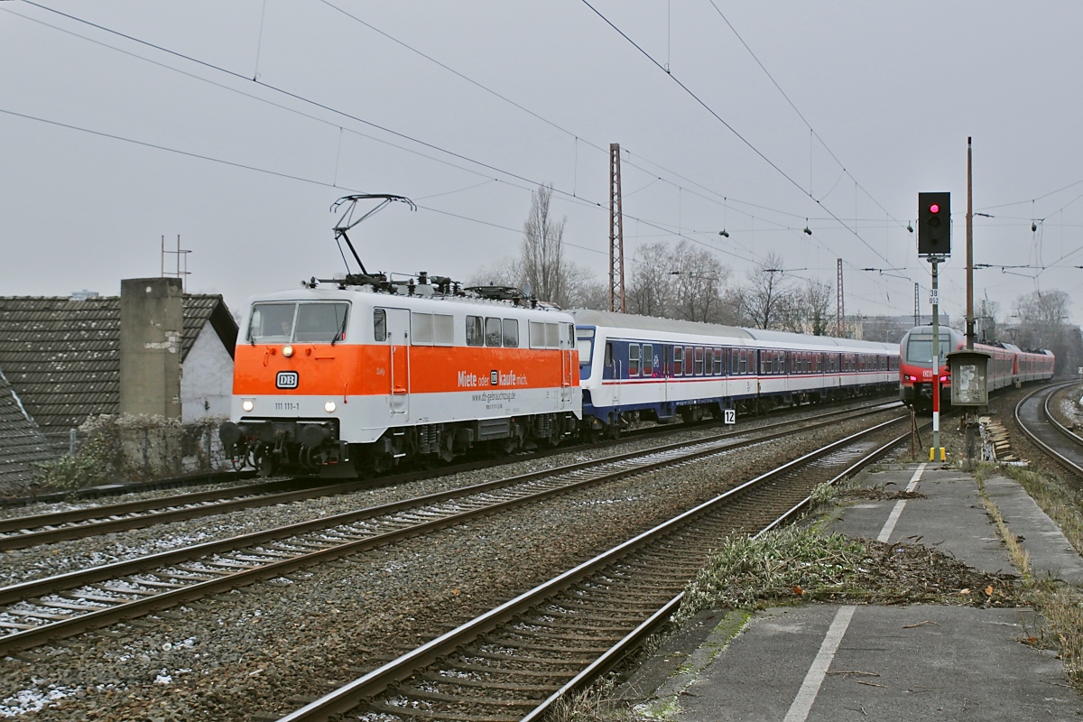 Neben der 110 469-4 wurde am 17.12.2022 auch die 111 111-1, die auf dieser Aufnahme in Mülheim (Ruhr) Hauptbahnhof ankommt, vor den Adventsverstärkerzügen eingesetzt 