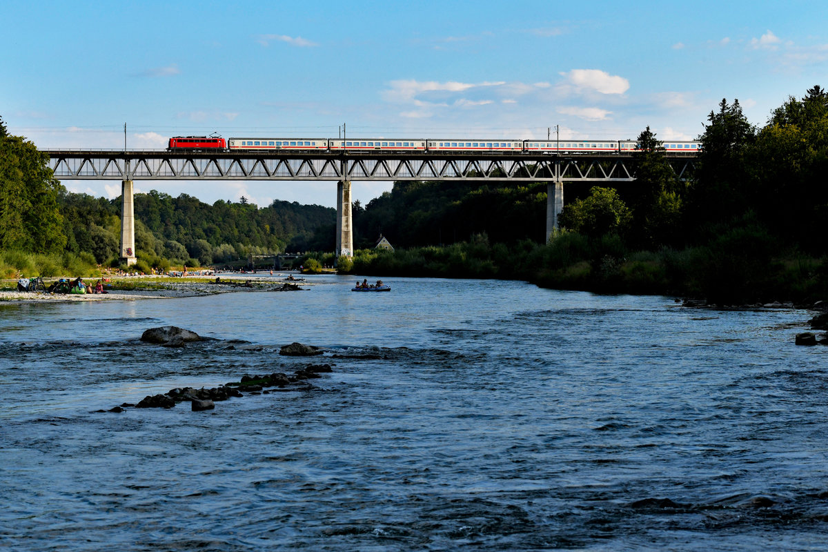 Neben dem bereits mehrfach gezeigten NightJet wurde auch ein weiterer interessanter Reisezug im Rahmen der Baumaßnahmen zwischen München und Rosenheim über das Mangfalltal umgeleitet. An Freitagen wurde der Leerpark für den sonntäglichen IC 1284 nach Wörgl überstellt. Am 27. Juli 2018 konnte ich den LPF 79105 beim Überqueren der Großhesseloher Brücke aufnehmen. Zuglok war stets eine Maschine der Baureihe 115, an diesem Tage die  Kasten-Zehner  115 261. Das Foto besitzt vermutlich bereits historischen Wert, in der nächsten Saison soll der  Großglockner  als ICE geführt werden und Umleitungsverkehr über Holzkirchen ist in nächster Zeit auch keiner zu erwarten. Für die zahlreichen Ausflügler, die an diesem heißen Tag an der Isar Entspannung und Abkühlung suchten, hatte dies natürlich keine Relevanz, für die anwesenden Fotografen jedoch durchaus. 