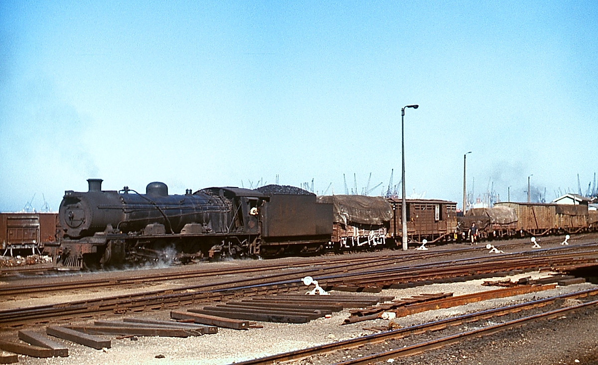 Neben den S2 wurde auch die ursprünglich für die Beförderung schwerer Güterzüge beschaffte Class 12R im Rangierdienst in Port Elizabeth eingesetzt. Hier verschiebt eine unbekannte 12R im November 1976 Güterwagen in Richtung Hafen (ungefähre Positionsangabe). 