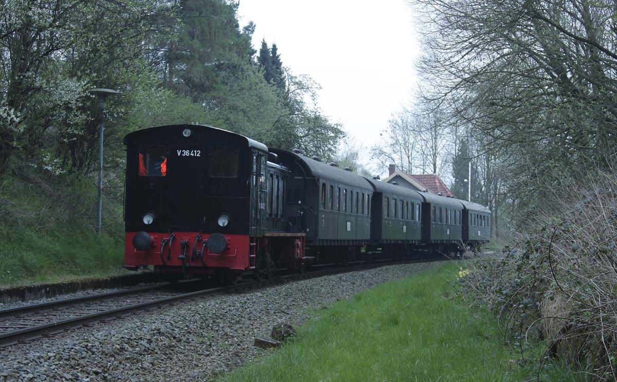 Nebenbahn Romantik auf der Hüttenbahn bei Osnabrück am 4.4.2014.
Eisenbahn Tradition war mit dem sogen. Rhodos Express mit Zuglok V 36412 an diesem Tag von Lengerich aus via Osnabrück und Hasbergen auf der Hüttenbahn von Hasbergen nach Georgsmarienhütte unterwegs. Nachdem die Zuglok im Werkbahnhof in Hütte umgesetzt hatte, fuhr man zurück bis nach Holzhausen, wo die Fahrgäste den Zug im ehemaligen Bahnhof Patkenhof verlassen konnten. Von dort ging man zu Fuß zu einer nahen Gaststätte zum  Dinner . Die Lokmannschaft war auch dabei, so dass der Zug für eine Weile im Patkenhof stand.