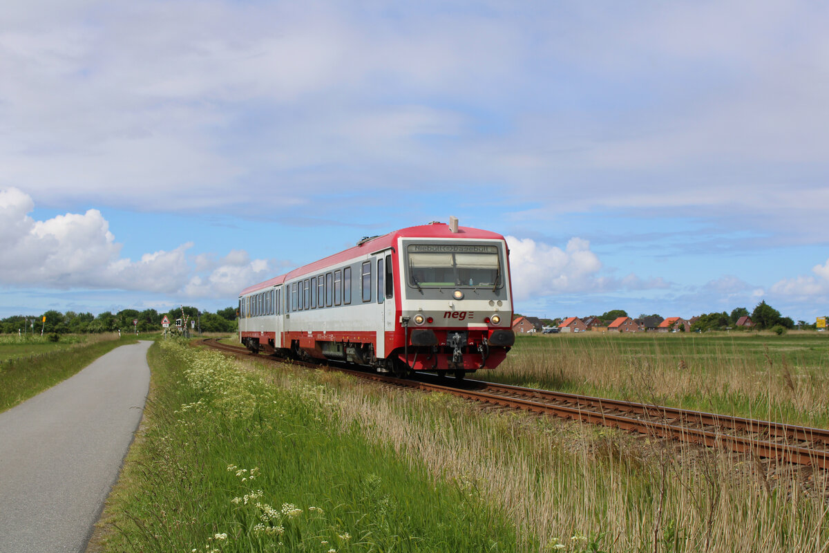 neg 628 071-2 fährt von Dagebüll Mole über die Kleinbahn nach Niebüll und ist hier gerade zwischen Dagebüll Kirche und Blocksberg unterwegs. (30.05.2022)