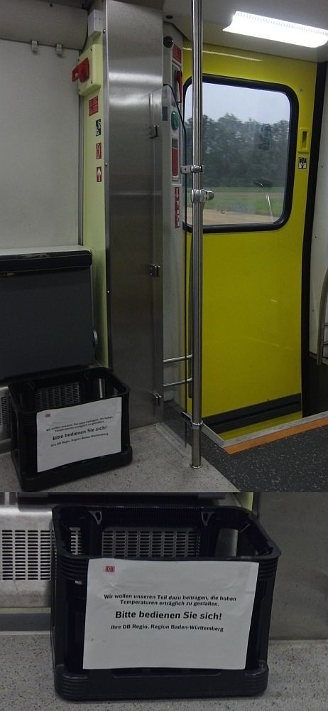 Nette Geste - Umsetzung verbesserungsfähig.
„Wir wollen unseren Teil dazu beitragen, die hohen
     Temperaturen erträglich zu gestalten.
           Bitte bedienen Sie sich!
     Ihre DB Regio, Region Baden-Württemberg“
ist auf dem Schild zu lesen.
Die Kiste für Getränkeflaschen stand am 28.07.2018 im IRE 3064 von Singen nach Waldshut.