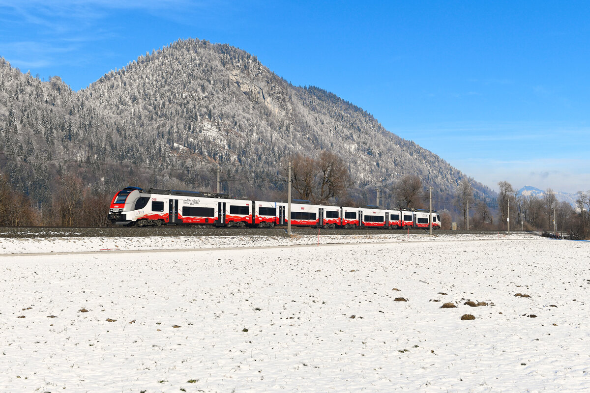 Neu im Tiroler Nahverkehr sind die Triebzüge der Baureihe 4748. Die Desiro ML von Siemens wurden anstelle der ursprünglich vorgesehenen Talent 3 von Bombardier angeschafft, da letztere aufgrund technischer Probleme keine Zulassung von den ÖBB erhielten. Die äußere Gestaltung mit den stilisierten Bergmotiven ist in meinen Augen als gelungen zu betrachten. Am 14. Januar 2024 konnte ich den 4748.031 als REX 5374 auf seiner Fahrt von Kufstein nach Innsbruck bei Langkampfen im unteren Inntal fotografieren.  