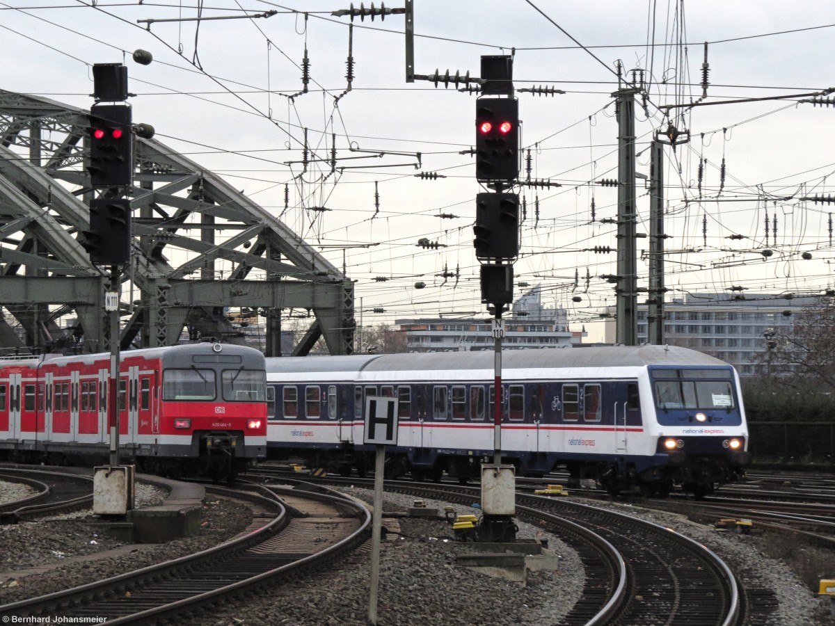 Neue alte Züge begegnen sich zwischen der Hohenzollernbrücke und dem Kölner Hbf. Als Ersatzzug für Talent 2 Züge hat National Express einige n-Wagem und Abteilwagen organisiert. Und durch zusätzliche S-Bahnfahrten im Netz der Kölner S-Bahn wurde der Fahrzeugpark mit Triebwagen der Baureihe 420 aus Stuttgart erweitert. Einer dieser Züge ist auf der S12 nach Hennef im Einsatz und begegnet der RB 48 bei der Einfahrt in den Kölner Hbf. Dezember 2015