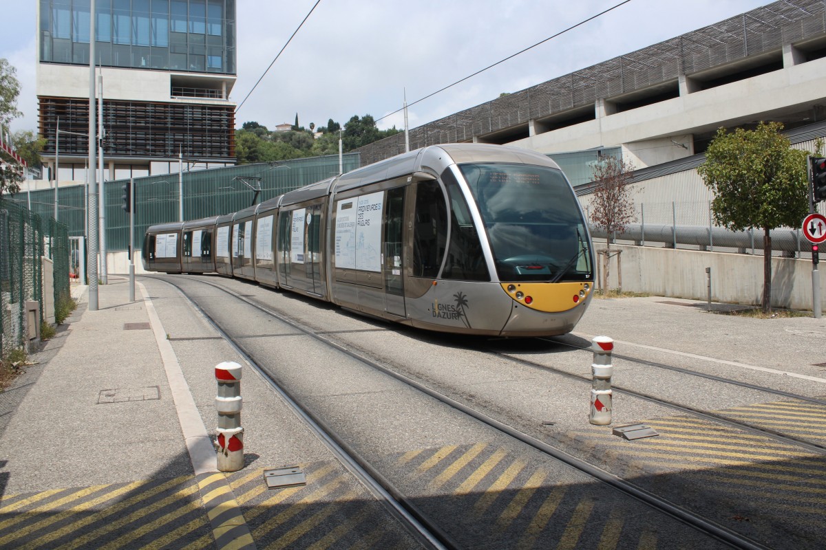 Nice / Nizza Lignes d'Azur SL T1 am 23. Juli 2015: Die Strassenbahn (Alstom Citadis-402 27) befindet sich wenige Meter vor der Endhaltestelle Henri Sappia (Las Planas). - Das Gebäude auf der rechten Seite der Strassenbahn ist der Betriebshof.