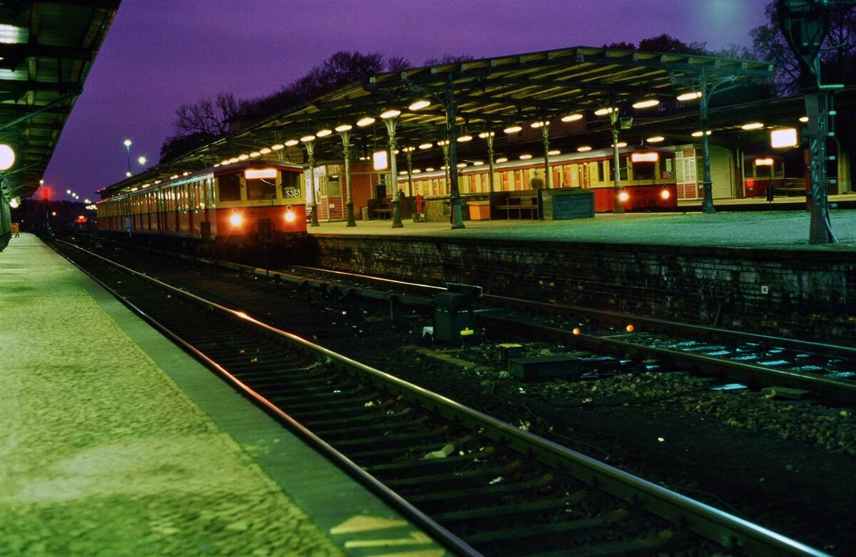 Nicht ein Bahnhof auf der Welt wirkte so nachhaltig auf mich wie der Bahnhof Wannsee. Vor allem bei Nacht , so empfand ich, evozierte er die deutsche Vergangenheit.
Hier warten gleich drei S-Bahnzüge im Bahnhof.
Datum: 02.02.1988