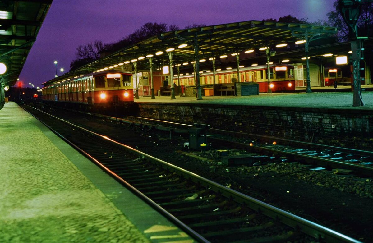Nicht ein einziger Bahnhof auf der Welt wirkte so nachhaltig auf mich wie der Bahnhof Wannsee. Vor allem bei Nacht, so empfand ich, evozierte er in der Zeit des Bestehens der DDR die deutsche Vergangenheit.
Hier warteten gleich drei S-Bahnzüge der früheren DR-Baureihe ET 165 (auch  Schnellbahner  genannt) auf ihre wenigen Fahrgäste Richtung Westen.
Datum: 02.02.1988
