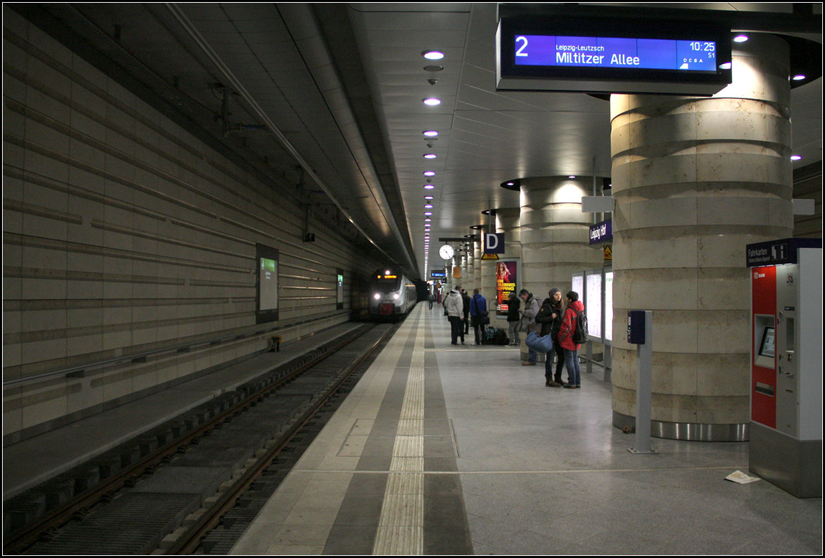 Nicht so luftig - 

wie die anderen neuen Stationen in Leipzig zeigt sich die Station unter dem Hauptbahnhof. Im Gegensatz zu den Bahnhöfen unter dem Markt und dem Wilhelm-Leuschner-Platz muss die Bahnsteighalle hier auch einiges tragen, da sich darüber Teile des Einkaufszentrums und des historischen Bahnhofsgebäude befinden. Massive Mittelstützen tragen die Last. Der Bahnsteig ist 215 Meter lang und könnte bei Bedarf in Richtung Norden auf 400 Meter Länge verlängert werden. Allerdings ist ein reguläre Fernverkehr durch den Tunnel momentan nicht vorgesehen. Die einzelnen ICE-Züge fahren hier lediglich baustellenbedingt vorübergehend. Auch ist die niedrige Bahnsteighöhe nicht ideal für Fernverkehrszüge.

Für die Architektur ist das Düsseldorfer Büro HPP Hentrich-Pentschnigg und Partner verantwortlich. Die Wände und Stützen wurden mit Naturstein verkleidet.

02.02.2014 (Matthias)