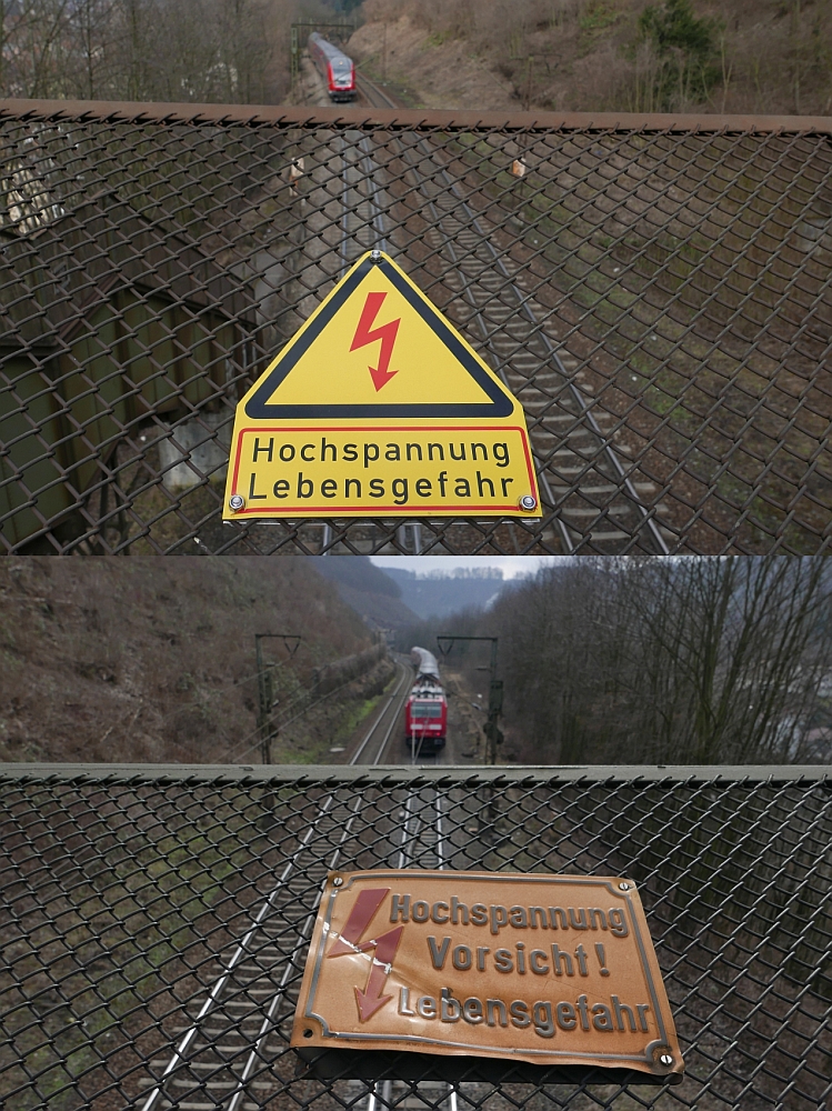 Nicht der Zug im Vordergrund - oder - neu und alt an einer älteren Brücke. Vor und nach der Durchfahrt eines RE unter der in Geislingen/Steige stehenden Fußgängerbrücke wurden die beiden unterschiedlichen, auf Hochspannung hinweisende Schilder fotografiert (12.03.2016).