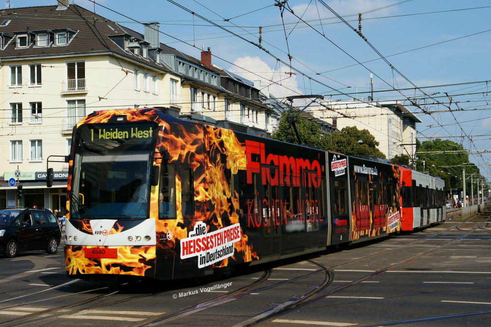 Niederflurwagen 4540 trgt als achtes Fahrzeug nach 4005, 4031, 4033, 4034, 4069, 4071 und 4111 die neue Ganzreklame  Flamme Kchen + Mbel . Hier zu sehen auf der Kreuzung Aachener Str./Grtel am 23.08.2013.
