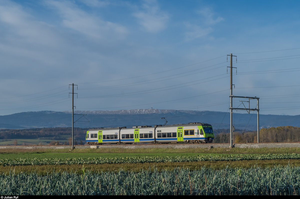 NINA RABe 525 003  Emme  durchfährt am 20. November als S5 Neuchâtel - Bern bei Kerzers das Grosse Moos. in Kerzers wird der Zug aus Neuchâtel mit dem Zug aus Murten vereinigt um danach gemeinsam nach Bern zu fahren. Im Hintergrund ist der Chasseral zu sehen.