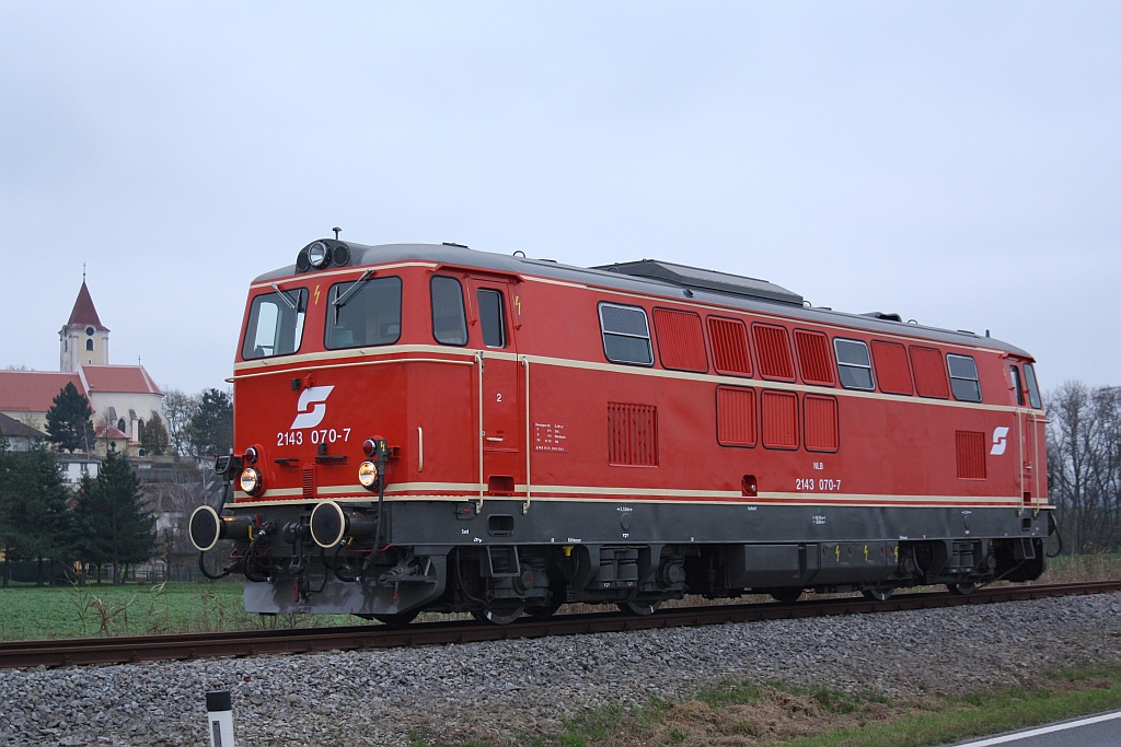 NLB 2143 070-7 als SLZ 17916 am 22.November 2014 bei Pernersdorf-Pfaffendorf. Im Hintergrund die Pfarrkirche Pfaffendorf.