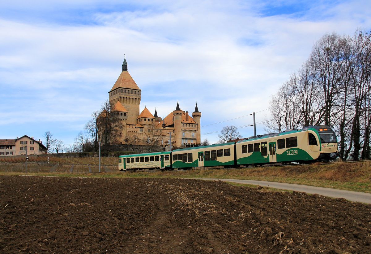 Noch ist der blaue Föhnhimmel da, doch das Schluss ist gerade in den Schatten geraten. Zug mit Triebwagen 38, dem neuen Zwischenwagen 2058 und dem etwas älteren Steuerwagen 51. Vufflens, 3.Februar 2017. 