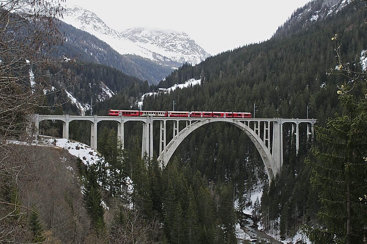 Noch einmal der Langwieser Viadukt der Arosabahn, diesmal von der bekannten Fotostelle mit Aussichtsbank unweit des Bahnhofs aus, am 31.03.2022 überquert ABe 8/12 3506 mit einem Zug nach Chur das imposante Bauwerk