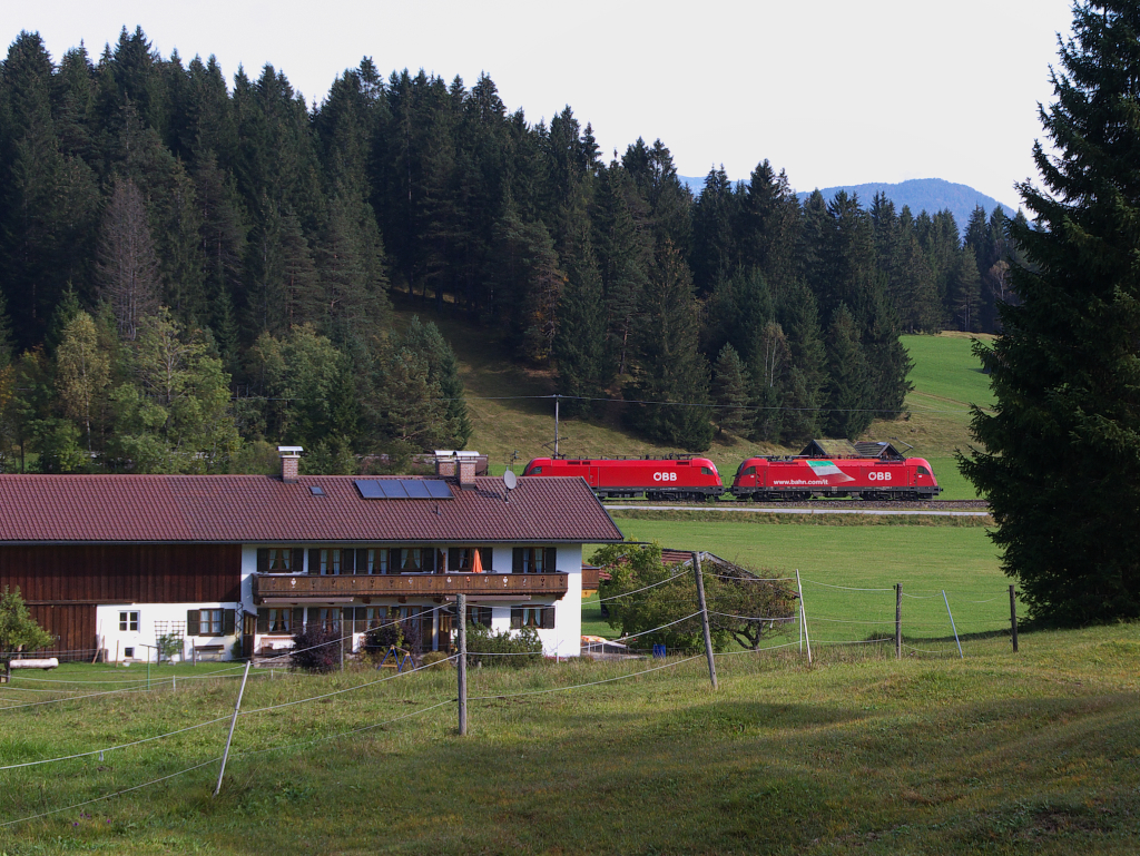Noch einmal zurück gerannt....Wir waren schon auf Wanderschaft zum Wildensee und hatten unser Feriendomizil verlassen, da pfiff es im Wäldchen hinter Klais.
Die RB nach Mittenwald war schon vorbei, eigentlich war Zugpause angesagt. Gerade an diesem Tag rollte der Güterzug Vils (Tirol) - Garmisch-Partenkirchen - Innsbruck - Hall (Tirol) zwei Stunden früher als sonst über die Gleise und noch in einer besonderen Bespannung. Also wir 100 Meter zurück gesprintet und schon rauschten zwei Tauri am Landhaus Wackerl vorbei. Im Normalfall sind ein Hercules und ein Taurus am Zug und es kam noch etwas nach........Bahnstrecke 5504 München Hbf. - Mittenwald Grenze - 06.10.2014
