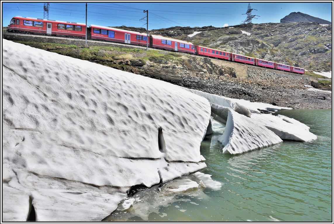 Noch liegen ein paar Eisschollen am Ufer des Lago Bianco als P4640 mit ABe 8/12 3503 vorbeifährt. (19.06.2019)
