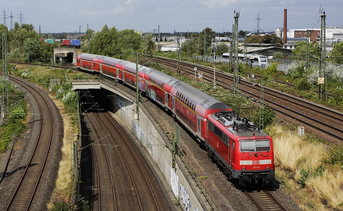 Nördlich des Neusser Hauptbahnhofes schiebt 111 113 am 10.08.2019 einen RE nach Düsseldorf, unten die S-Bahn-Gleise und rechts die Strecke nach Krefeld