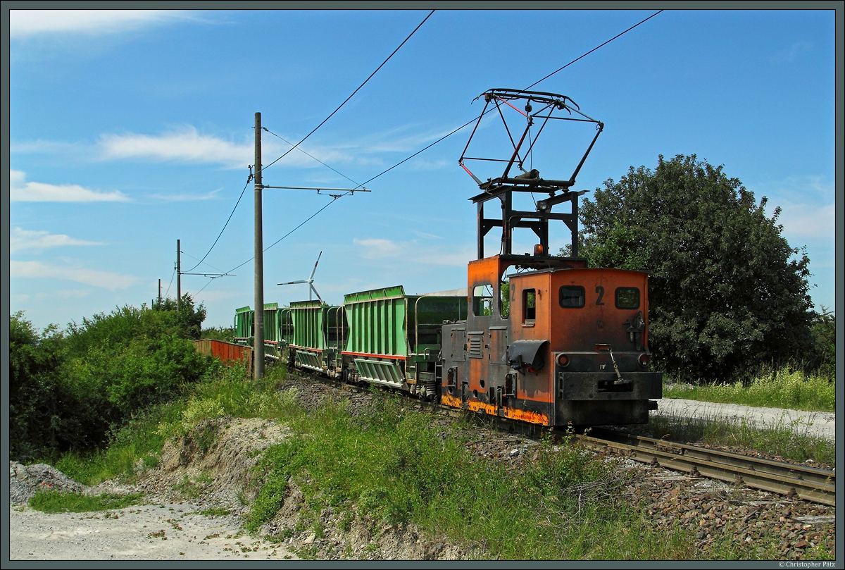 Nördlich von Staßfurt überquert die 600mm-Werkbahn des Sodawerkes die Bahnstrecke nach Magdeburg. Am 31.05.2014 rollt Lok 2 (LEW EL 12, 1976) mit einem Leerzug über das Überführungsbauwerk. 