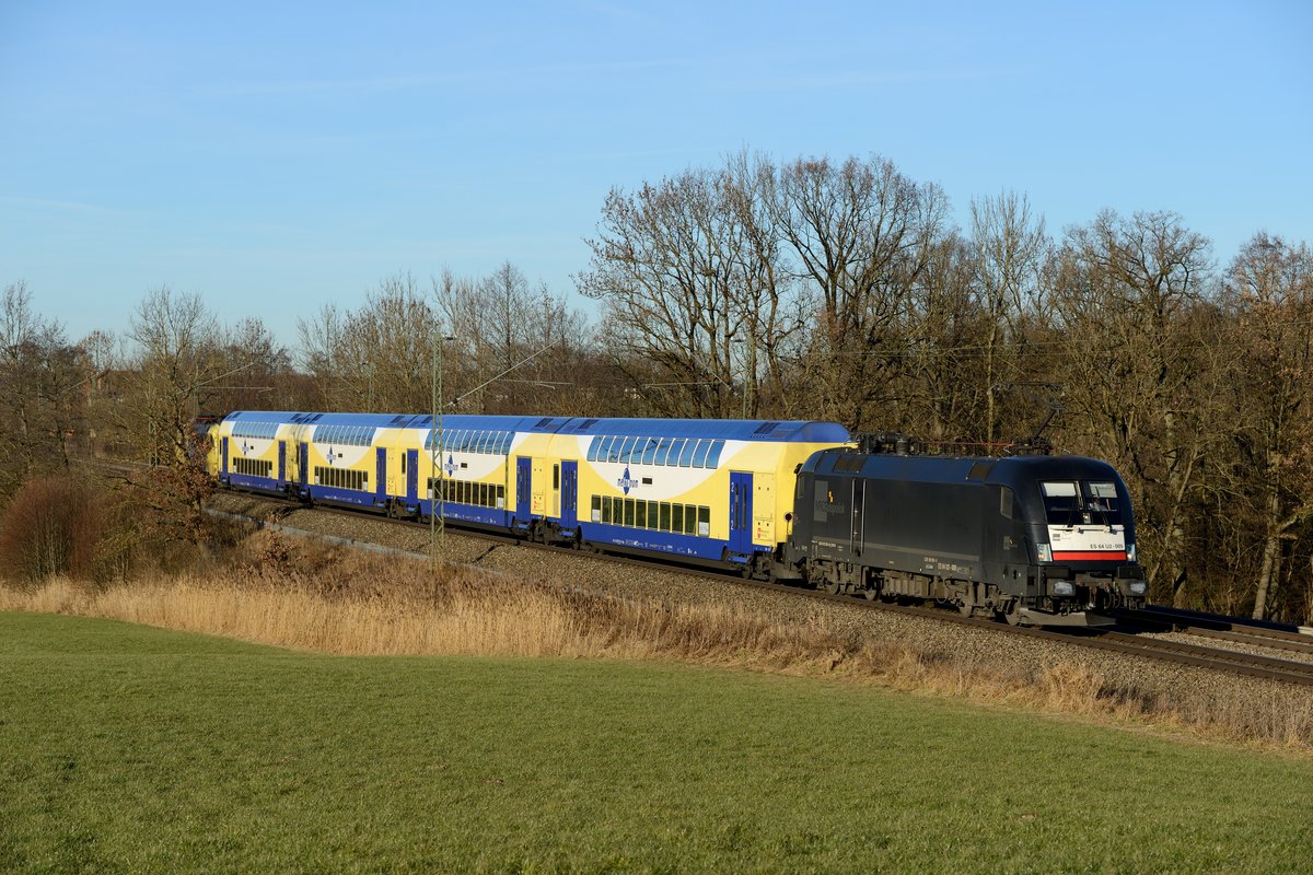 Norddeutschland zu Gast in Bayern: Im Rahmen des Meridian Ersatzzug-Konzepts hatte es auch vier Doppelstockwagen des Metronoms nach Oberbayern verschlagen. Gefahren wurde diese Garnitur mit einer Sandwich-Bespannung ES 64 U2. Am frühen Nachmittag konnte diese außerplanmäßige Leerfahrt bei Bach am ehemaligen Block Hilperting fotografiert werden. Es führt die ES 64 U2 009 von MRCE Dispolok.