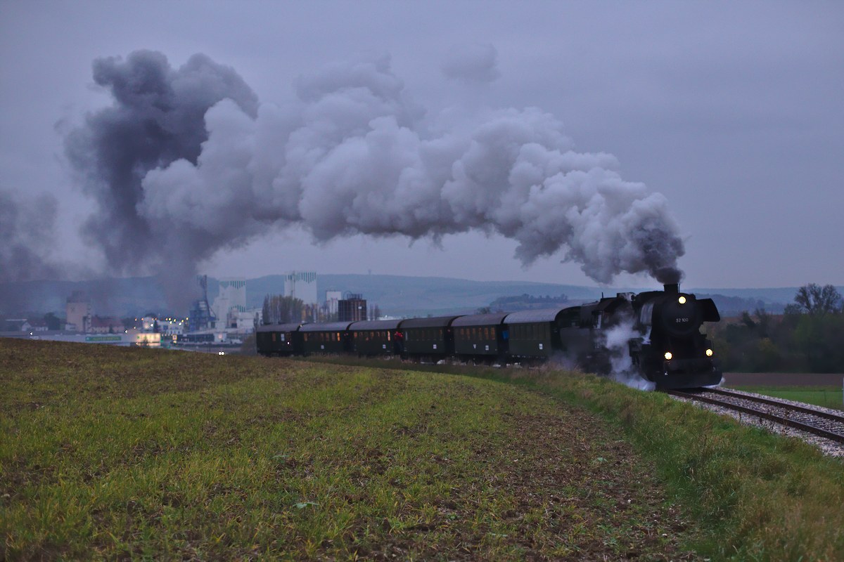 Normaler Weise fahren die Dampfzüge auf der Landesbahn immer mit dem Kamin voraus nach Ernstbrunn. Am Nationalfeiertag bot sich die einzigartige Gelegenheit, die 52.100 mit der Kamin voraus in Richtung Korneuburg festzuhalten. Das Bild zeigt den Zug im allerletzten Licht kurz nach der Abfahrt aus Ernstbrunn; im Hintergrund ist das Kalkwerk zu sehen, das bis vor kurzem ein wichtiger Bahnkunde war. (26.10.2014)