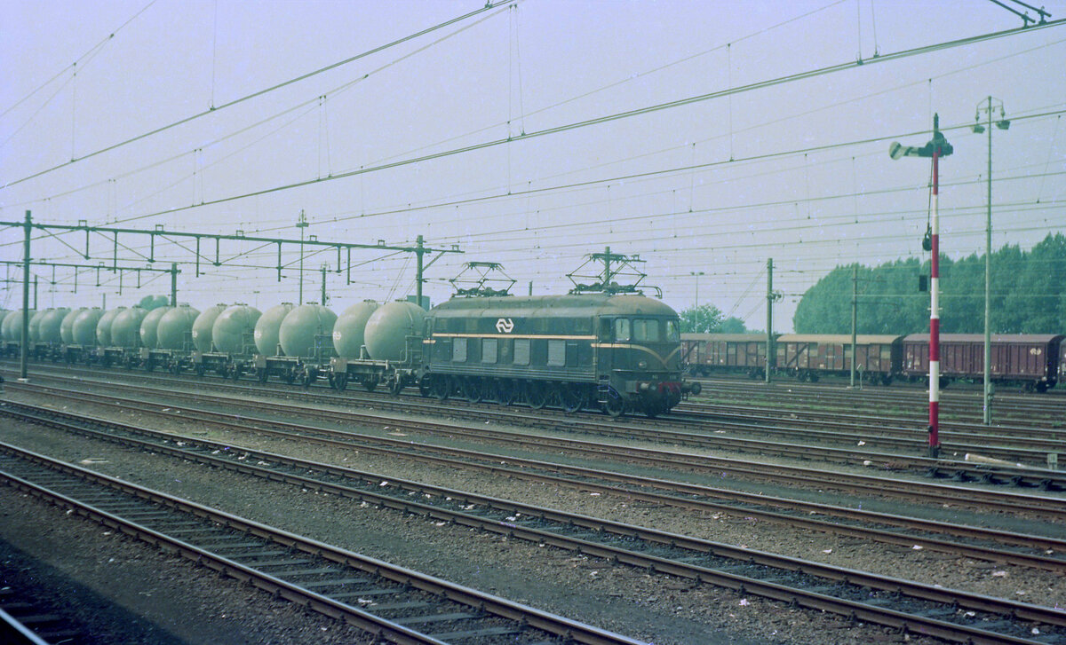 NS 1005 mit 9 Silowagen in Roosendaal am 30.08.1975. Vermutlich handelt es sich um Zug 720524 von Goes nach Rotterdam Zuid G. Scanbild 90509 (Bahnsteigbild), KodacolorII.