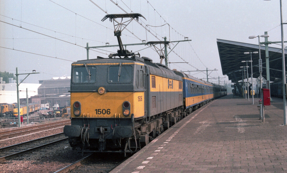 NS 1506 am Bahnsteig in Tilburg mit IC-2508 (K�ln Hbf - Den Haag CS) am 27.09.1983. Scan 93234.