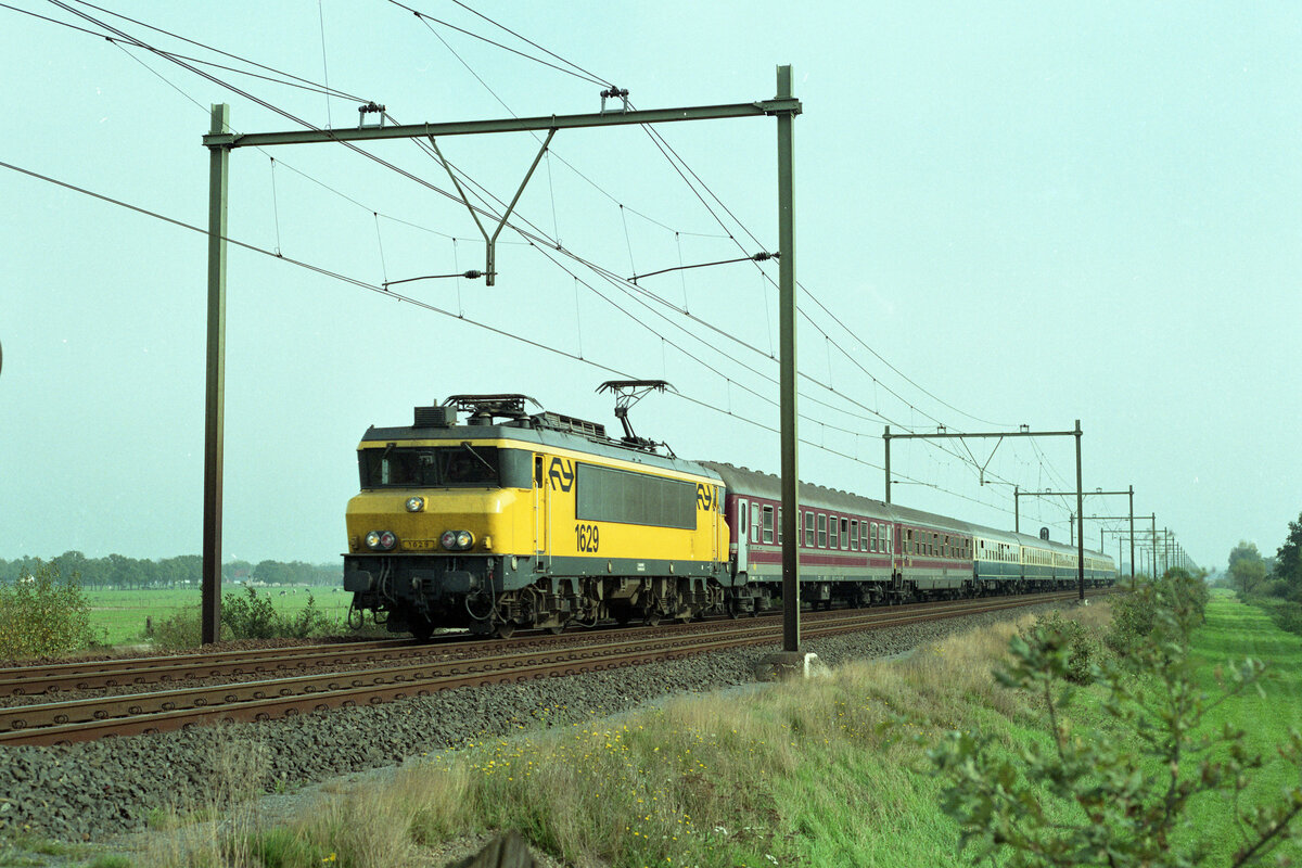 NS 1629 mit IC-204 (Duisburg Hbf - Amsterdam CS) bei Veenendaal De Klomp am 14.10.1990,13.27u. Hinter der Lok laufen 2 Italienische Bm der FS, ferner 6 Stück der DB.Scanbild 95463, Kodak Ektacolor Gold.