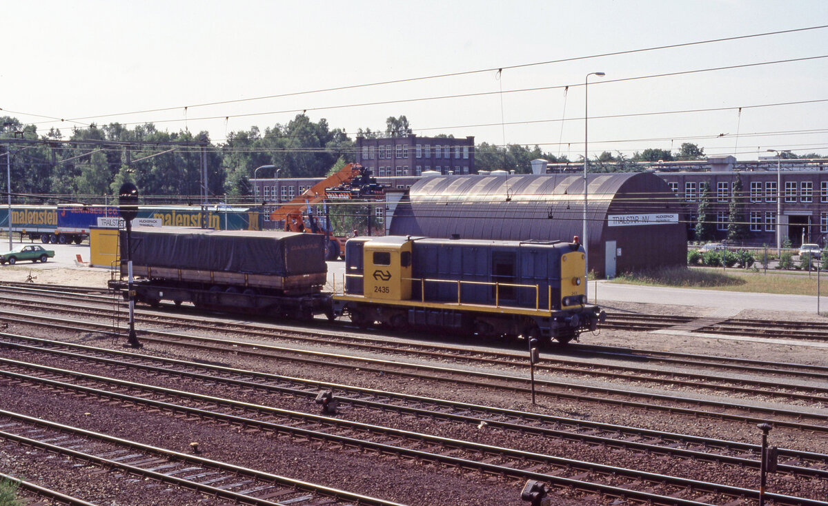 NS 2435 wartet am Huckepack Terminal der fa Trailstar in Ede-Wageningen am 04.07.1989. Aus einen Baum im Waldgebiet gegenüber bot sich diese Aussicht. Scan (Bild 4962, Ektachrome100HC).