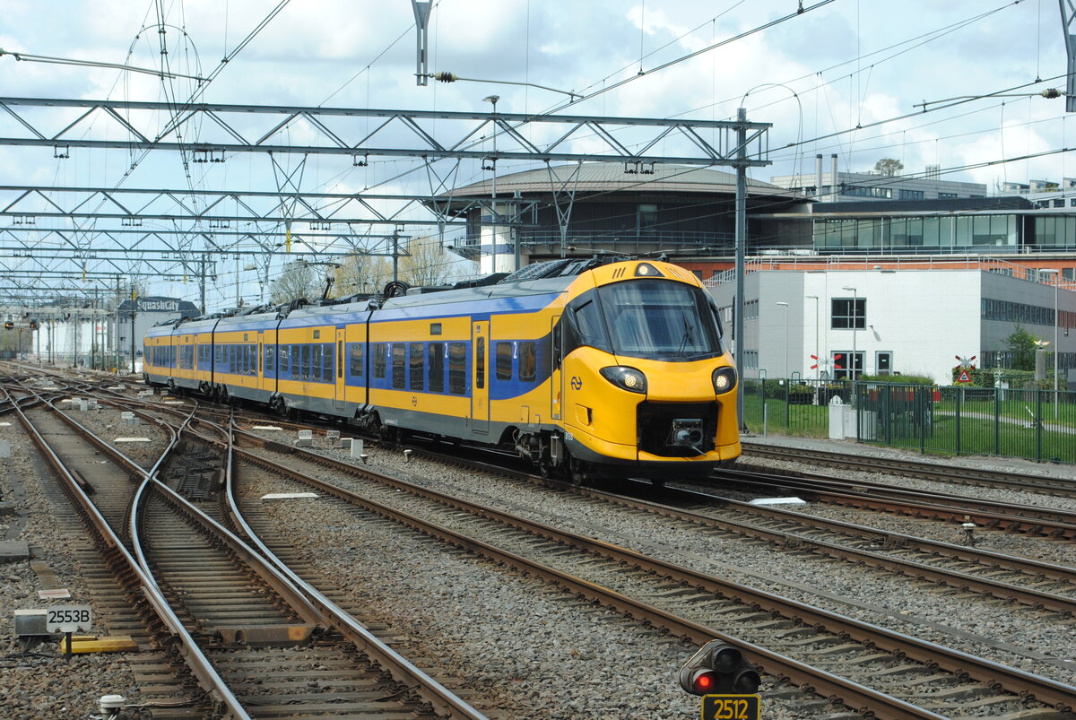 NS 3133 kommt vorbei am ProRail Gebäude am Bahnhof Amsterdam Centraal am 26.04.2023, als Leerzug unterwegs zum Betriebsbahnhof Watergraafsmeer. Bild 22958.