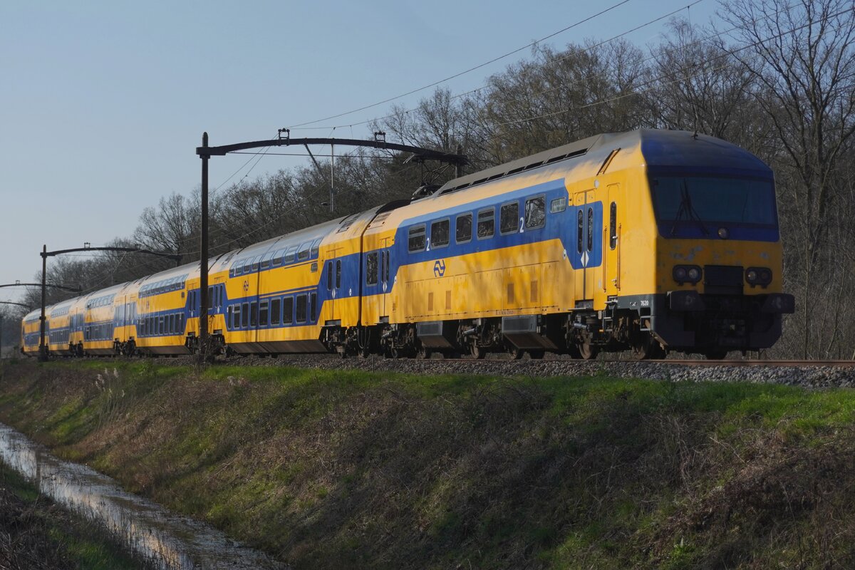 NS 7620 durchfahrt Tilburg Oude Warande am 18 März 2026 als IC nach Zwolle und wird vom offenbarer Fusspfad fotografiert. Der Oude Warande ist ein in 18.Jahrhundert angelegter Waldpark ins Westen Tilburgs und ist nicht nür für Wandere ein feines Ort, doch auch für Eisenbahnfans während Ümleitungen von Guterzüge.