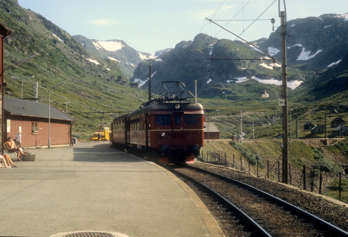 NSB Bahnhof Myrdal am 4. August 1982. Am Bahnsteig hält ein Personenzug der Flåmsbanen.