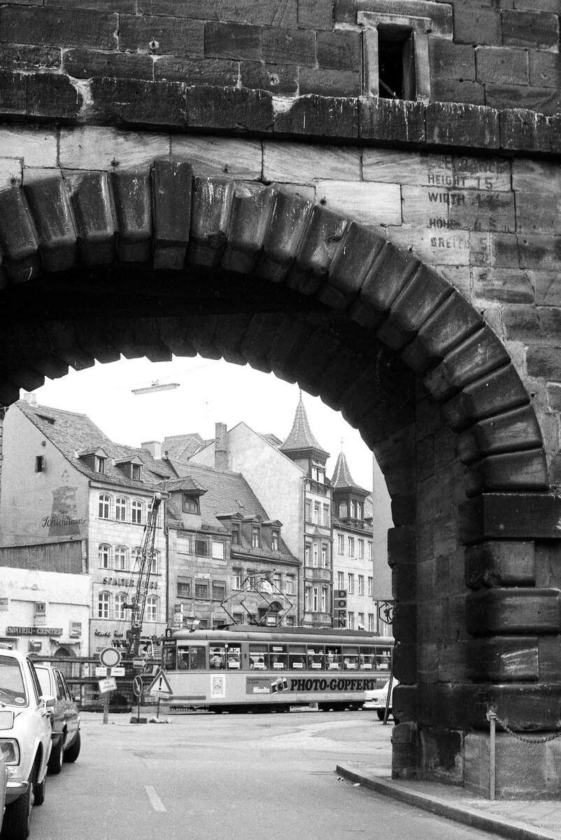 Nürnberg-Fürther Straßenbahn__Blick aus der Gegenrichtung: vom Waffenhof zur Ludwigstr. mit 4x -Zug der Linie 6. Interessant die noch lesbare historische Beschriftung am Torbogen. Nicht mittelalterlich, sondern  amerikanisch  (aus den 40er Jahren).__15-06-1976