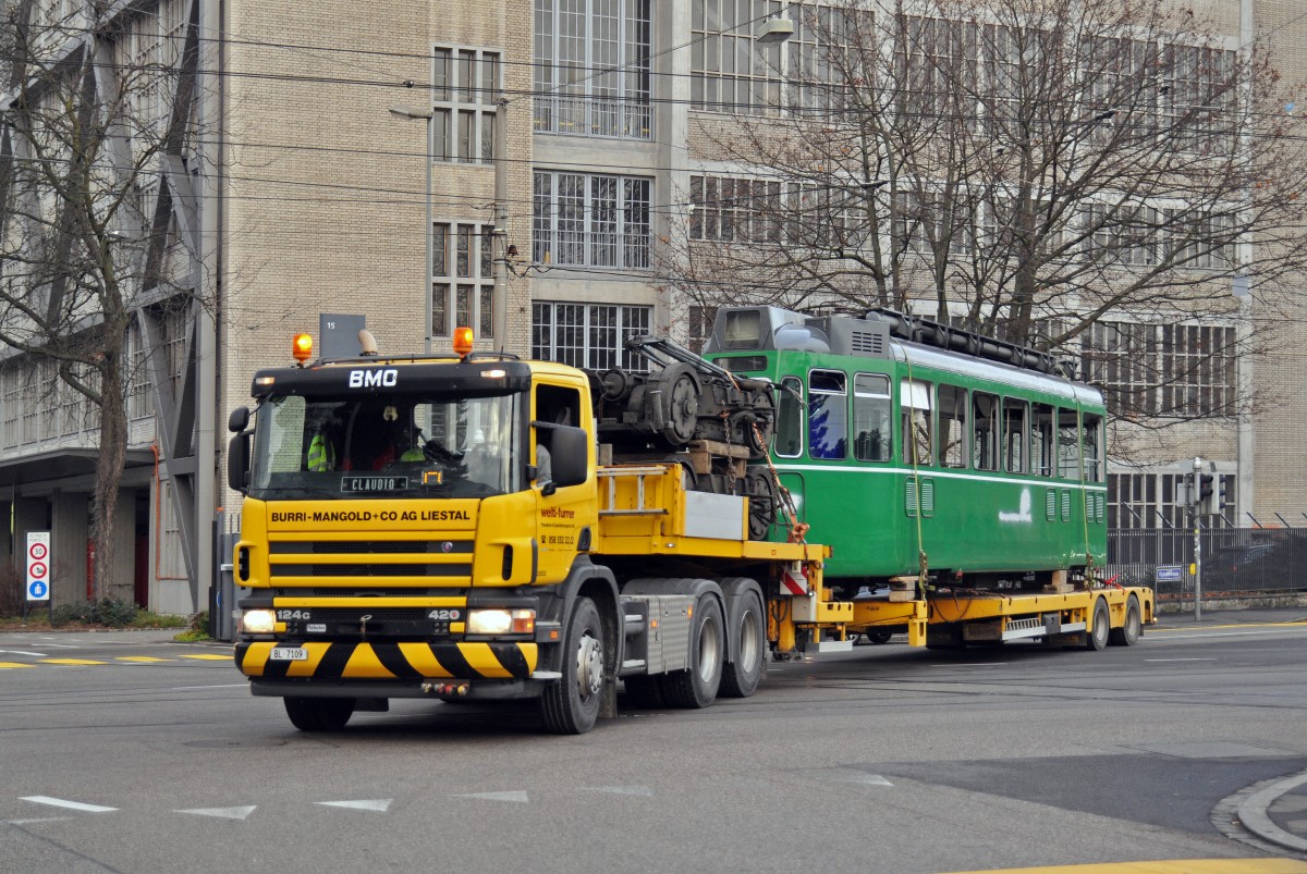 Nun ist der Be 4/4 460 an der Reihe. Am 18.12.2015 wird er in der Hauptwerkstatt aufgeladen und tritt die letzte Reise an. Hier fährt der Lastwagen über die Kreuzung bei der Haltestelle CIBA der Linie 8.