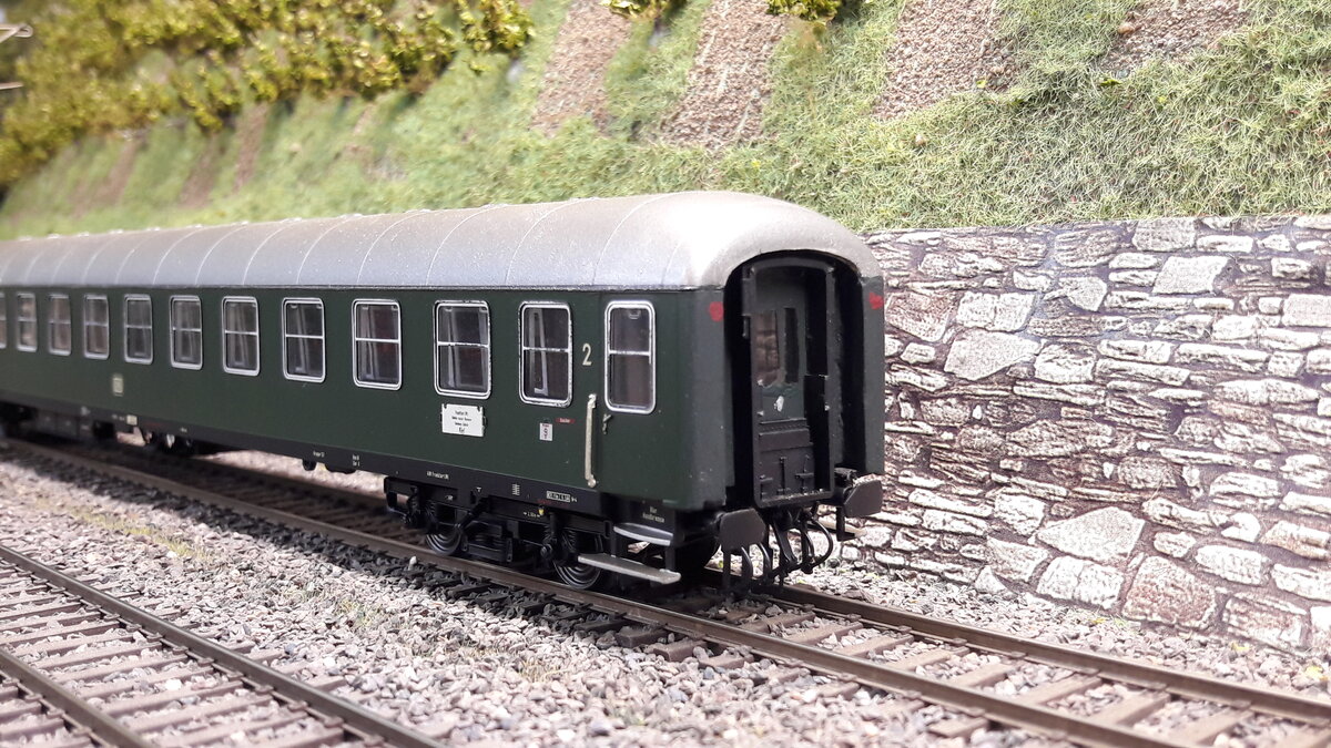 Nun etwas m-Wagen (UIC X Wagen ) Geschichte. Gebaut ab 1953 als erste 26,4m Reisewagen der DB. Die sogenannte Klassenreform der DB Wagen ( also mehr oder weniger Abschaffung der 3.Klasse fand ab 1956 statt ). Die allersten 26,4m m-Wagen waren 16 sogenannte Probewagen. Sie zählten noch zur Gruppe 39 bzw 52. Sie sahen so aus wie man unsere Bm Wagen kennt, hatten jedoch zu Anfang keine Gummiwülste sondern tatsächlich Faltenbalgübergange. Es gab von diesen Probewagen 10 C4üm (heutige 2.Klasse Bm Wagen ), 3 AB4üm ( heutige 1.Klasse Bm-Wagen ) und 3 ABC4üm ( heutige 1/2.Klasse Bm-Wagen). Später wurden sie auf Gummiwulst umgebaut. Hier nun zu sehen ein C4ümg 2.Klasse , nach der Klassenreform von 1956 als 2.Klasse Wagen. Nun zum Modell, NOCHMAL IN NAHAUFNAHME ,dieser Wagen ist ein Unikat !!! Er wurde von mir so umgebaut, und ist entstanden aus einem Wagen von LS Models. Exakt 1:87. Das Modell eines der ersten Probenwagen der DB. Es gab Ihn tatsächlich einmal von Trix noch aus den 50er oder 60er Jahren. Kaum als Bm Wagen zu erkennen. Bis heute hat kein Hersteller diesen Wagen in exakter Form und 1:87 je gebracht.