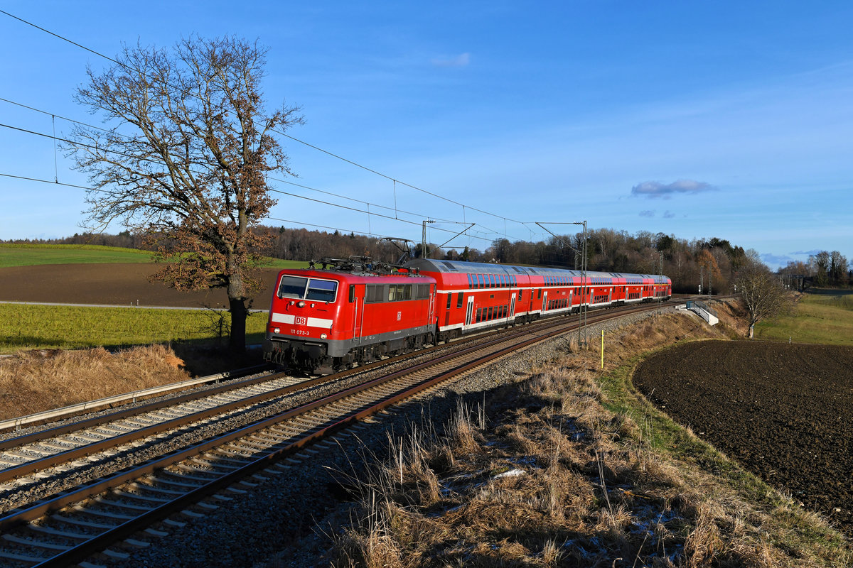 Nur ein kurzes Intermezzo wird der Einsatz der Baureihe 111 zwischen München und Memmingen bleiben. Ab Fahrplanwechsel im Dezember wird GoAhead die Leistungen übernehmen. Bis dahin kann man sich an den Bundesbahn-Klassikern auf dieser Strecke erfreuen. Am 26. Dezember 2020 nahm ich bei Kottgeisering die 111 073 vor dem RE 57410 auf. Die Lok wurde erst kürzlich aus Ulm übernommen, der Lack wurde durch eine Ceramol-Behandlung aufgefrischt.  