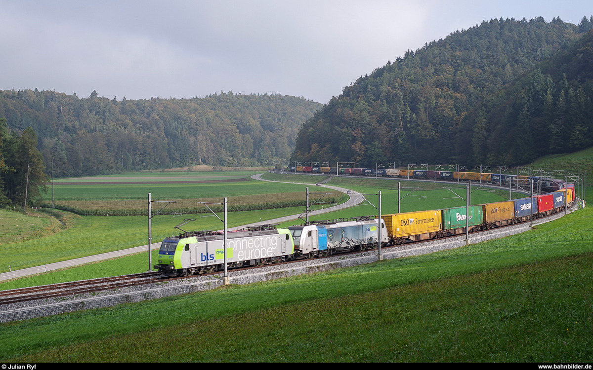 Nur kurz schaute die Sonne am 4. Oktober 2014 morgens hinter den Wolken hervor, doch das reichte um die BLS Cargo Re 485 012 zusammen mit einer unbekannten von Railpool angemieteten Re 486 mit ihrem bunten Containerzug fotografisch festzuhalten.