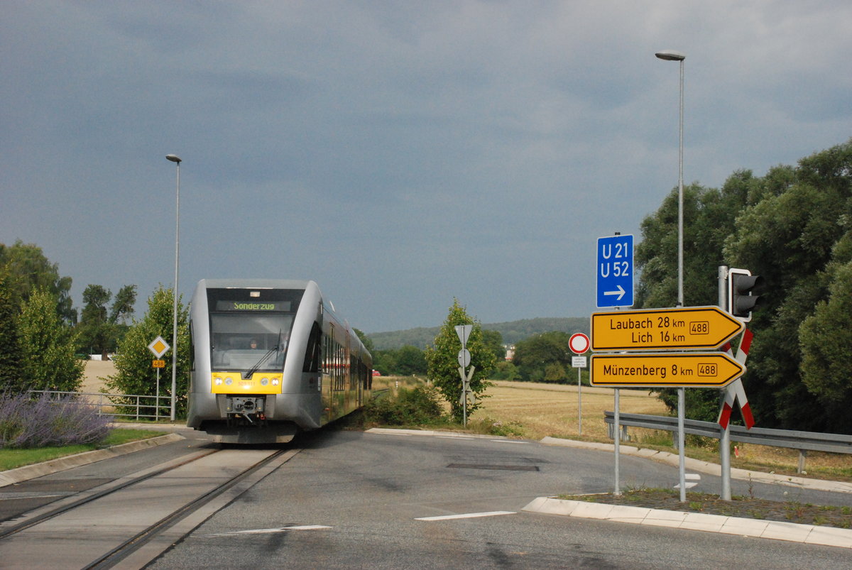 Nur selten kann man am im Kreisel zwischen Butzbach und Griedel integrierten Bahnbergang Schienenfahrzeuge beobachten. Meist sind es sporadisch verkehrende Holzzge zwischen Mnzenberg und Butzbach. Am 20.7.2014 wurde jedoch eine Gtw-Doppeleinheit der HLB nach Bad Nauheim berfhrt (die heute reaktivierte Verbindung zur DB in Bad Nauheim war damals noch nicht wiederhergestellt), um anlsslich des  Steinfurther Rosenfestes  Pendelfahrten zwischen Bad Nauheim und Steinfurth auf der ehemaligen BLE zu unternehmen. 