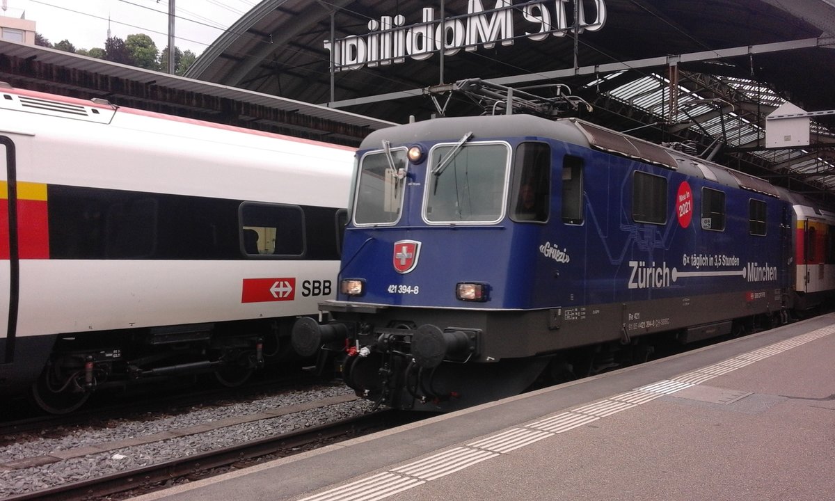 Ob die Re 4/4 weiss, dass sie Werbung für ihren Bruder RABDe 503 macht? Jadenfalls ist es noch Zukunftsmusik, und die Re 4/4II 11394 (Re 421 394) bespannt hier den Erocity nach Zürich, den sie seit Lindau am Haken hat. Soeben hat der Zug den Fahrbefehl erhalten und verlässt St. Gallen.

St. Gallen HB, 14.06.2020