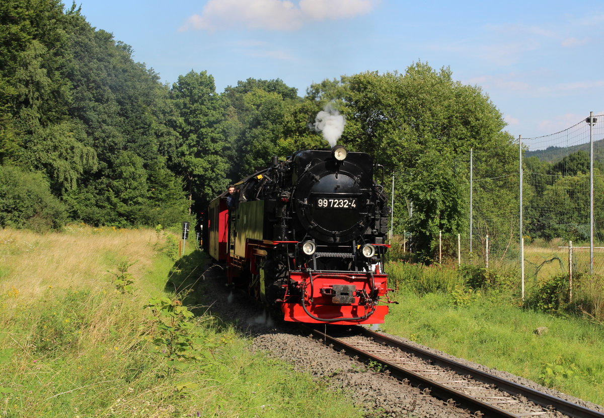 Oberhalb des Bahnhofes von Hasserode dampft 99 7232 mit dem P8939 (Wernigerode - Brocken) am Hasseröder Fußballplatz vorbei.

Wernigerode Hasserode, 14. August 2017