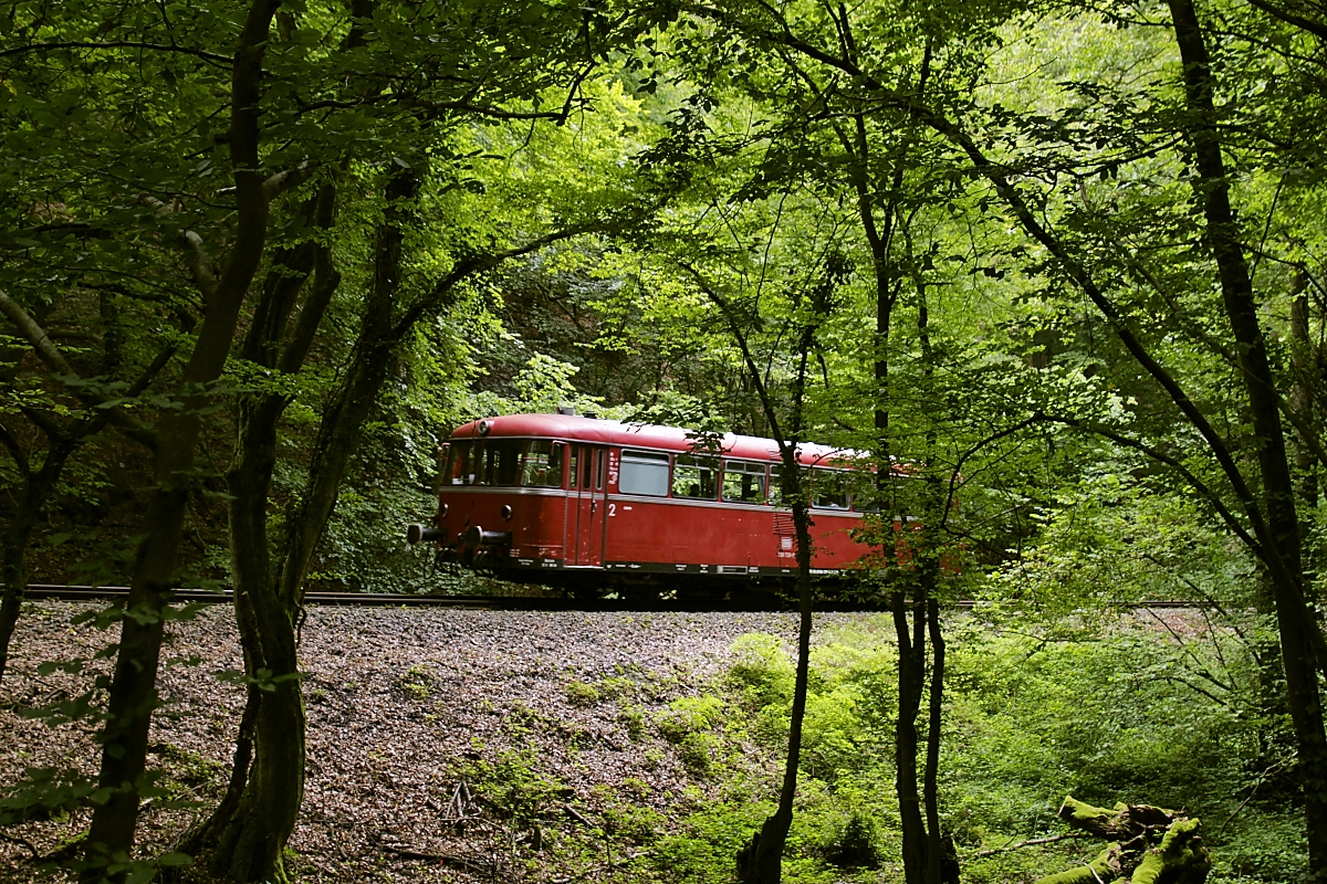Oberhalb von Kasbach führt die Strecke durch dichtes Grün, das nur wenige Fotomöglichkeiten zulässt, hier ist 798 729-0 oberhalb der Haltestelle Brauerei Steffens am 07.08.2021 nach Linz unterwegs