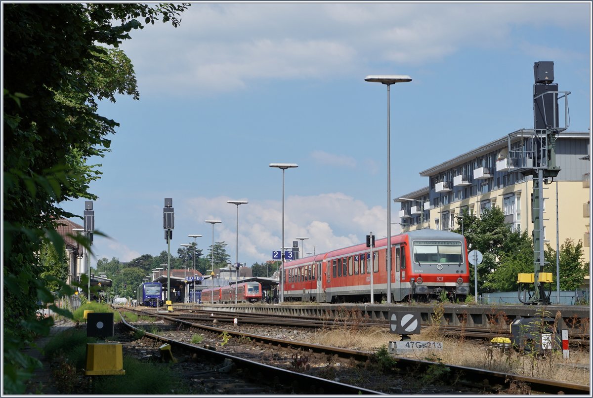 Obwohl Friederichshafen Stadt (noch) keine Fahrleitungsanlage aufweisst, gibt es doch genügend Pfosten und Masten welche die Sicht auf die Züge einschränken könne.
Im Bild der von Lindau in Friedrichshafen Stadt einfahrende VT 628 als RB 22714, im Hintergrund zwei VT 611 und zwei BOB VT 650.
(Hinwwis: Das bild entstand am Bahndamm von einer öffentlich zugängien Treppe aus) 
16. Juli 2016