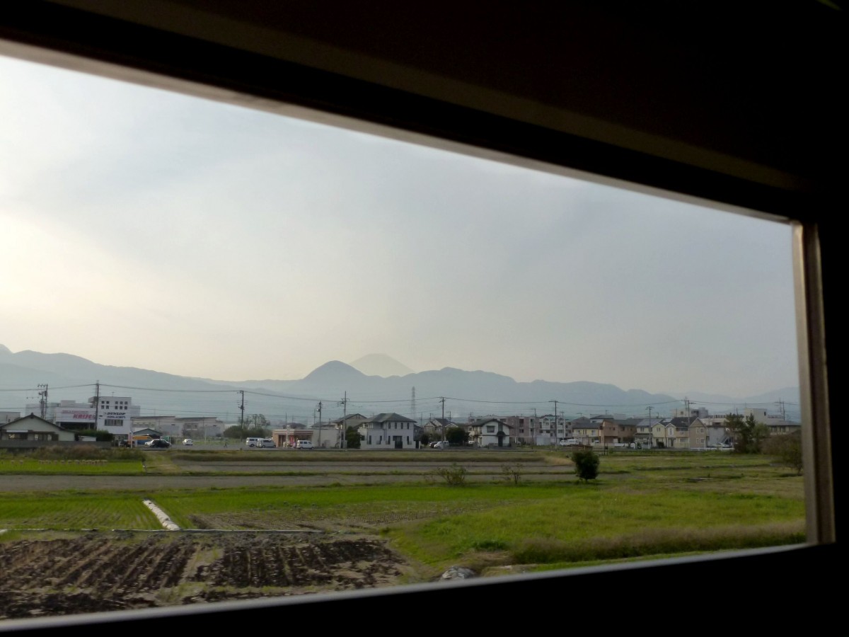 Odakyû Konzern, Serie 3000: Ganz am Ende der Strecke, nach 80 Kilometern Fahrt, gibt es immer noch Häuschen von Pendlern nach Tokyo. Viele Leute hier freuen sich über die Nähe zum Berg Fuji, der im abendlichen Dunst sichtbar ist. Aufnahme aus Zug 3093, zwischen Kaisei und Shin Matsuda, 2.November 2011. 