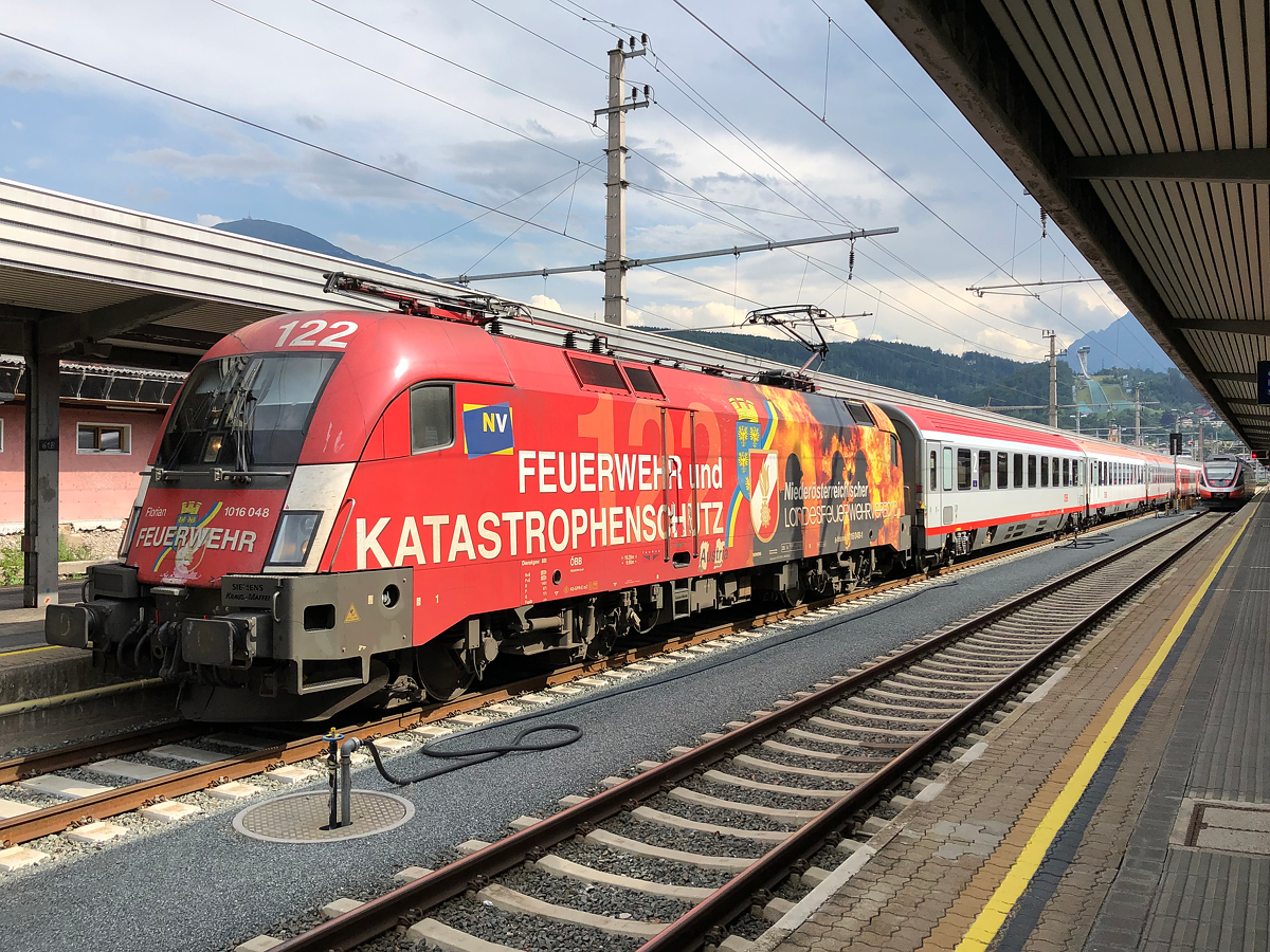 ÖBB 1016 048-1  Niederösterreichischer Landesfeuerwehrverband  wartet mit REX 5333 am Bahnsteig 6 auf die Abfahrt nach Kufstein. Innsbruck Hbf am 30.07.2021