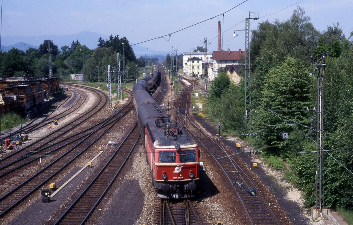ÖBB 1044.020 fährt am 13.6.1987 um 11.02 Uhr mit einem Schnellzug aus Richtung München kommend in Freilassing ein.