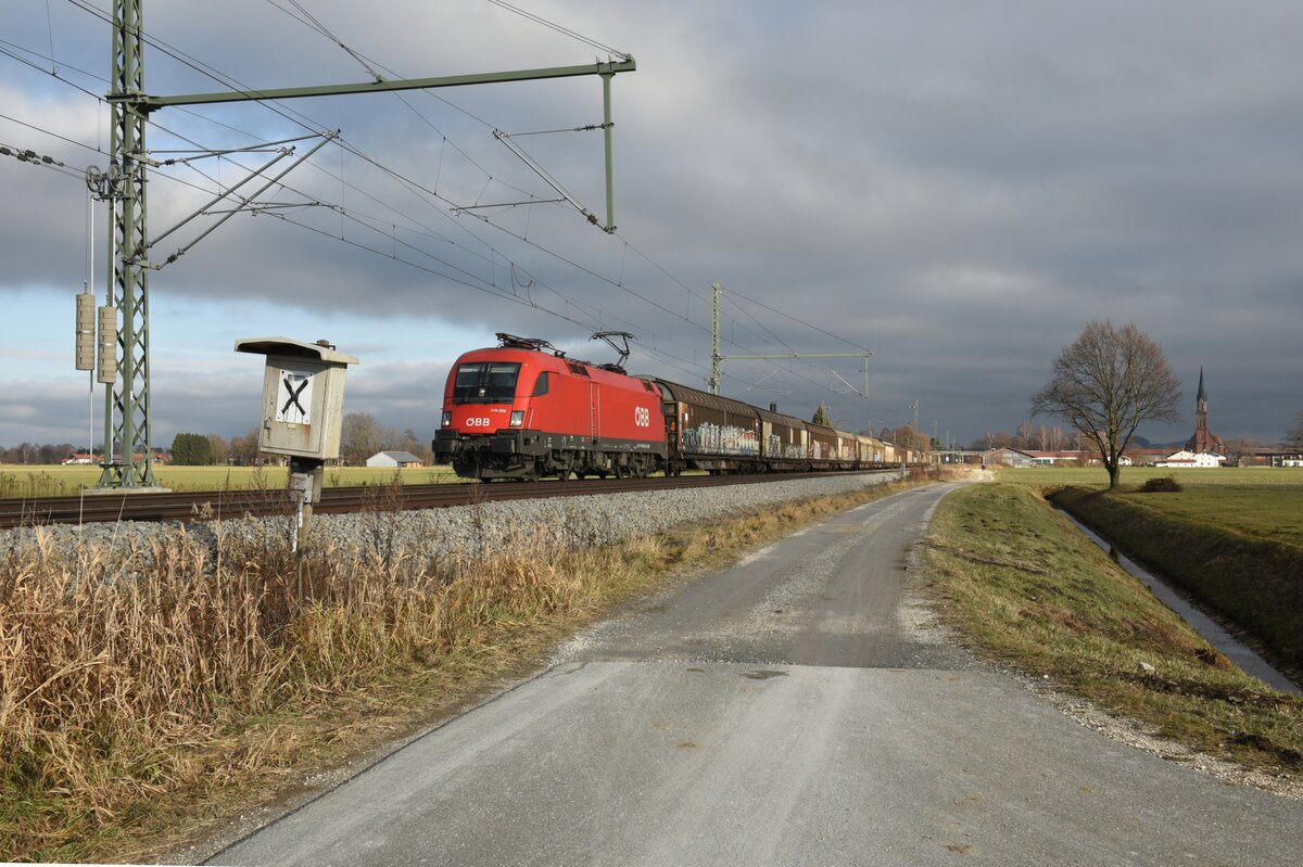 ÖBB 1116 058 mit Containerwagen auf der Strecke Salzburg in Richtung München kurz nach Übersee am Chiemsee. Aufgenommen am 17.12.21 